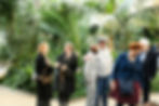 Gruppo di persone in conversazione in un giardino, durante un incontro professionale in un contesto verde e raccolto