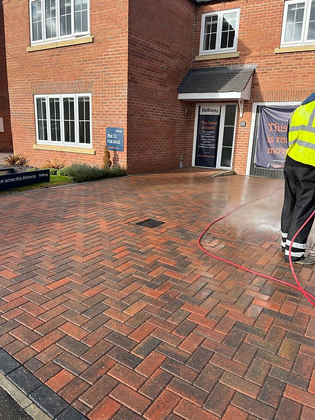 A driveway after it has been power washed, making the bricks look as good as new.
