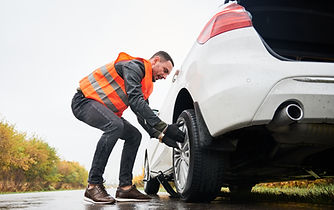 emergency-auto-mechanic-changing-flat-tire-road.jpg