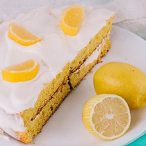 close-up-decorated-lemon-cake-white-plate-with-lemons-wooden-table_23-2147972737.jpg