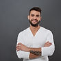 young-handsome-man-smiling-with-crossed-arms-grey-wall.jpg