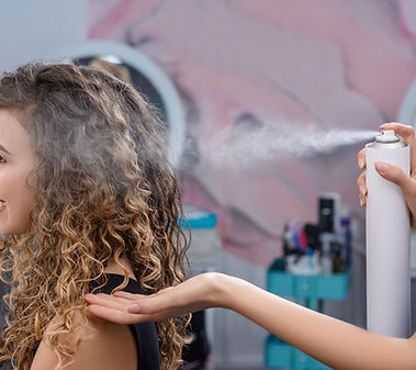stylist-fixing-hairstyle-with-hairspray-beauty-salon.jpg