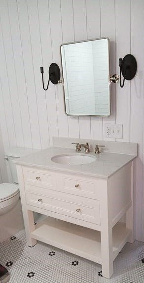 A bathroom with white walls and furniture.