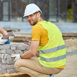 two-workers-stacking-bricks-looking-came