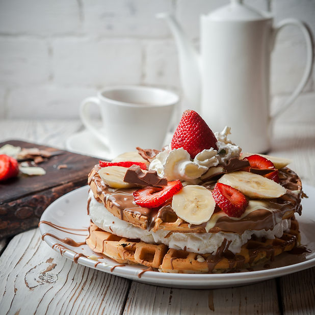 side-view-waffle-ice-cream-cake-with-strawberry-cup-teapot-round-white-plate.jpg