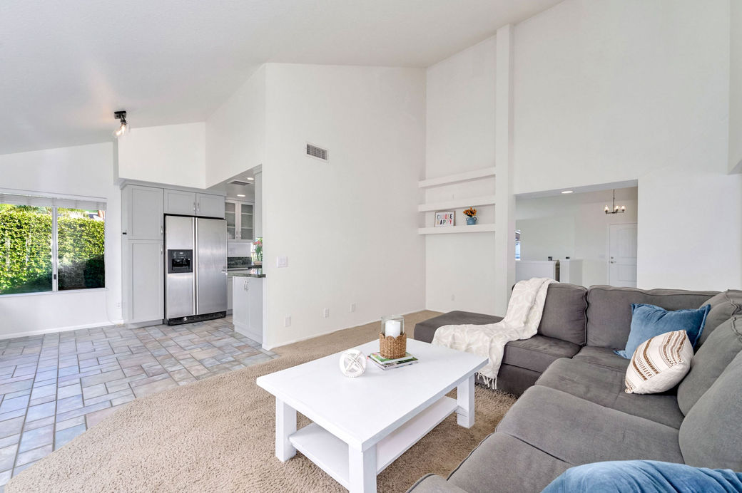 Family room with vaulted ceilings, open layout, and view toward the kitchen.