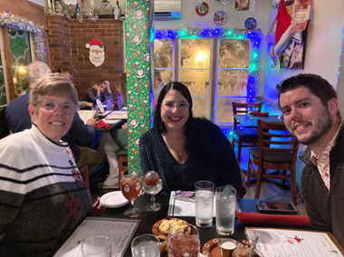 A mom, her daughter, and her son-in-law dining at a restaurant