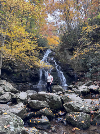 A woman standing in front of Spruce Flats Falls