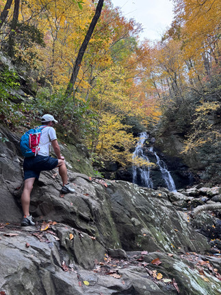 A man standing in front of Spruce Flats Falls