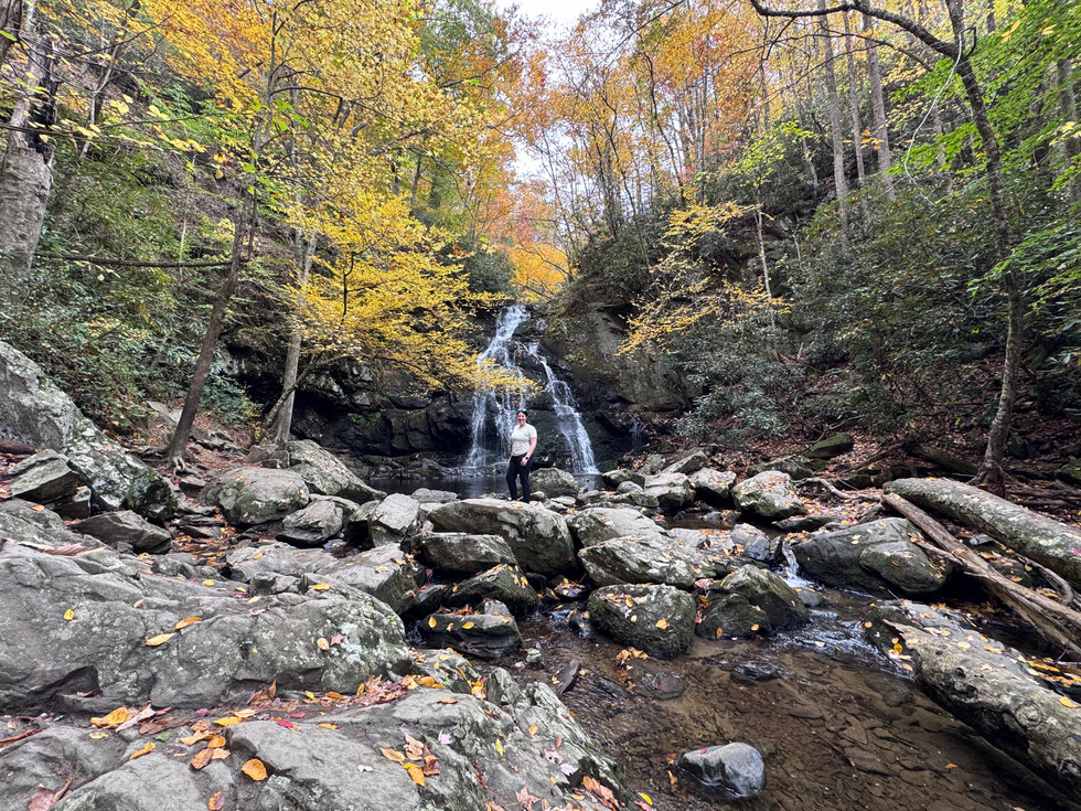 A woman standing in front of Spruce Flats Falls