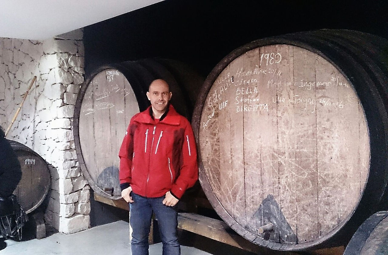 Iván de pie junto a los enormes barriles de Fondillón