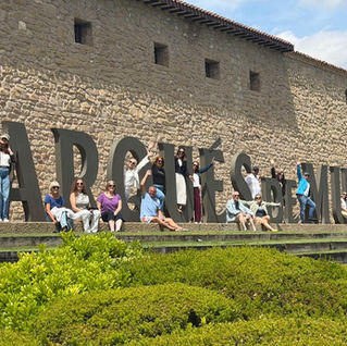 Our wine weekenders sitting or standing in front of the Marques de Murrieta signage at the bodega.