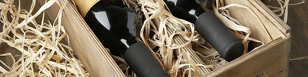 Dos botellas de vino en una caja, rodeadas de relleno de paja