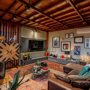 Sala de TV de casa de campo com forro em madeira (piso do mezanino), móveis em couro e concreto aparente — design sofisticado e contemporâneo