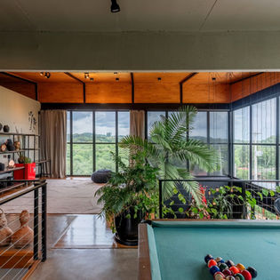 Pavimento superior da casa de campo que une arquitetura em madeira e arquitetura industrial, piso em assoalho de madeira mesclado com piso de cimento queimado, peitoril em cabos de aço, parede em painel de concreto aparente, sala de estar e sala de jogos, assinatura Arquiteta Isabella Dalfovo.