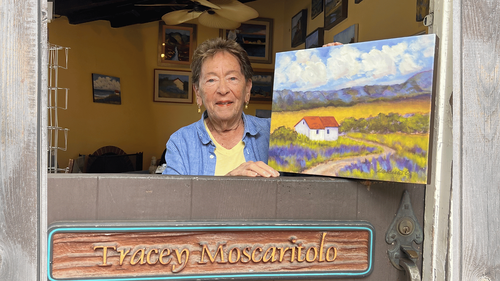 Tracey showing her paintings after surviving multiple cancers.