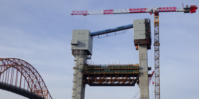 Field view showing the 5.5 m deep truss assembly suspended between the tower legs beneath the crossbeam pour.