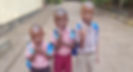 Photo of 3 Upendo children in school uniforms making the peace sign