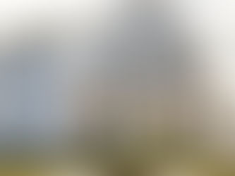 A two-story blue house with white trim, lit by porch lights. Lush greenery lines the front, and an airplane is visible in the cloudy sky. This image represents 3d room design.