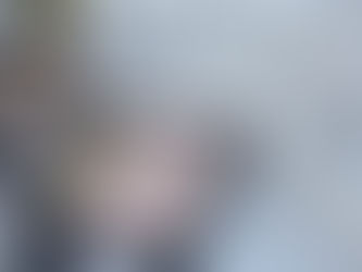 Person holds a tablet showing design plans, standing near a brick wall. The tablet screen displays "HB Design & Engineering." Calm setting. The image is used to represent residential engineer near me.