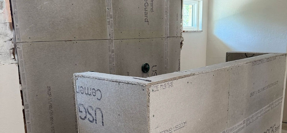 Construction site with cement boards installed in a room, partially built walls, window in background. Bathroom addition made by Built with Love in St Petersburg, Florida.