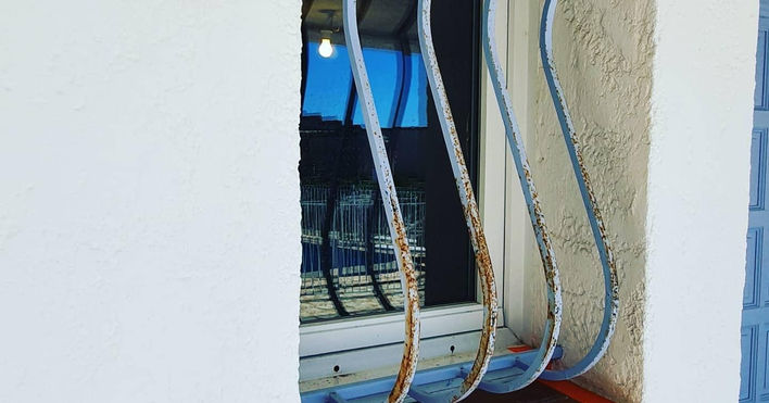 Het aanbrengen van zwarte verf op een ijzeren balustrade, waardoor een elegante en duurzame afwerking ontstaat.