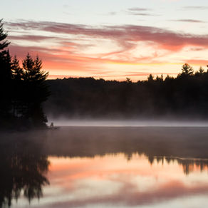 Mist and pink sunlight over the water in Alognquin Park