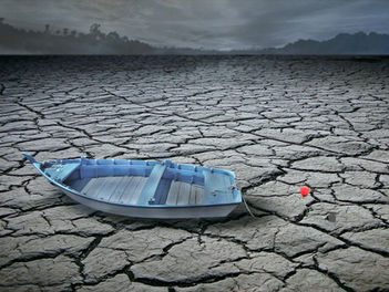 blaues Boot auf dem tTrockenen mit roter Mohnblume
