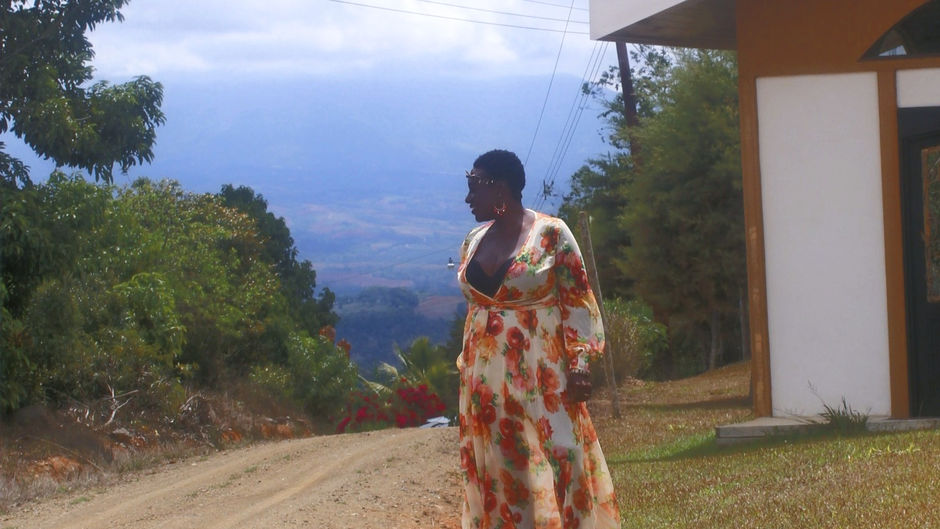 Full-length photo of woman standing between historic building and open road under blue sky, reflecting on faith and becoming whole.
