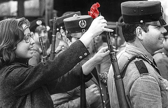 Femme (Celeste Martins Caeiro ?) mettant un oeillet dans le canon d'un fusil, Centro de Documentação 25 de Abril, Coimbra, avril 1974.