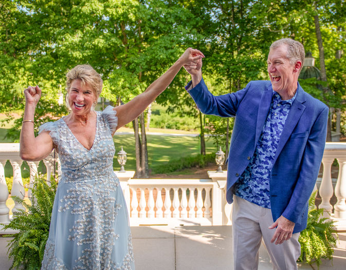 An older couple laughing and celebrating together outdoors by Loren Matzick Photography.