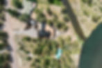 Aerial view showing the property’s layout, private driveway, and riverside setting.
