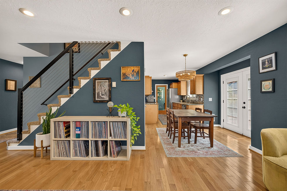 The living room, dining area, and kitchen connect seamlessly, with an updated staircase and oak floors carrying the warmth throughout.