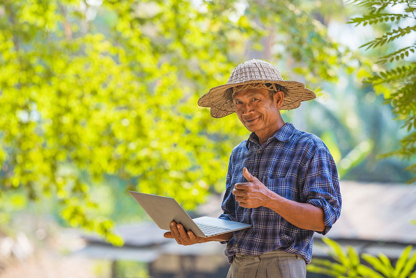 Farmer Asian with smartphone and laptop,Business and technology concept.jpg