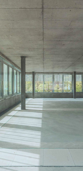 Detailaufnahme der Fensterfronten und der Bodenfläche im 5. Stock des Töss Campus bei Tageslicht.