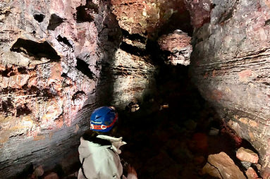 Lava Tunnel in Iceland with a girl wearing a helmet and a white jacket