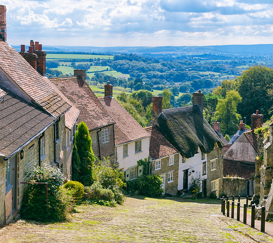 Bright scenic landscape view of the rolling green countryside from the cobblestone street