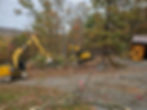 Excavators clearing wooded site and preparing land for construction
