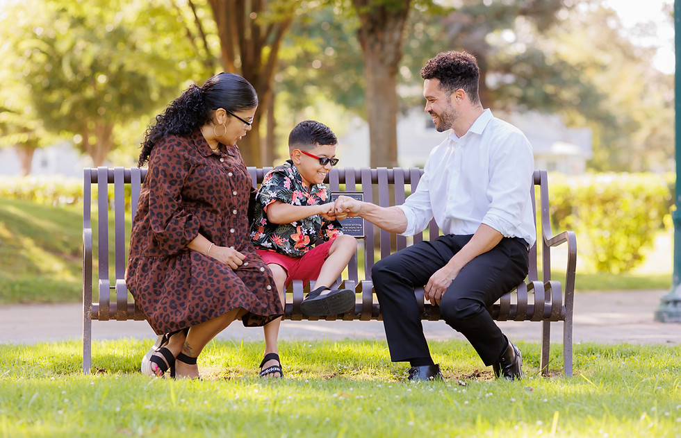 Connor on a bench with a woman and her child