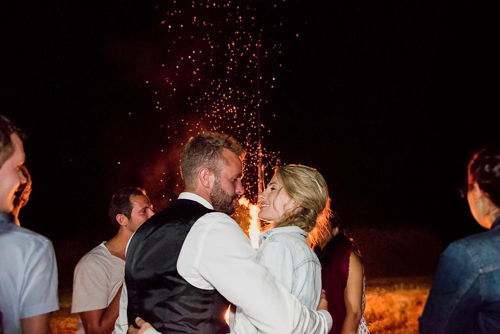 les mariés se regardent et s'embrassent devant l'immense feu allumé pour leur mariage