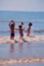 Children jumping and splashing in sea 