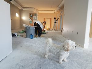 A full home renovation where a worker is cleaning the wall.