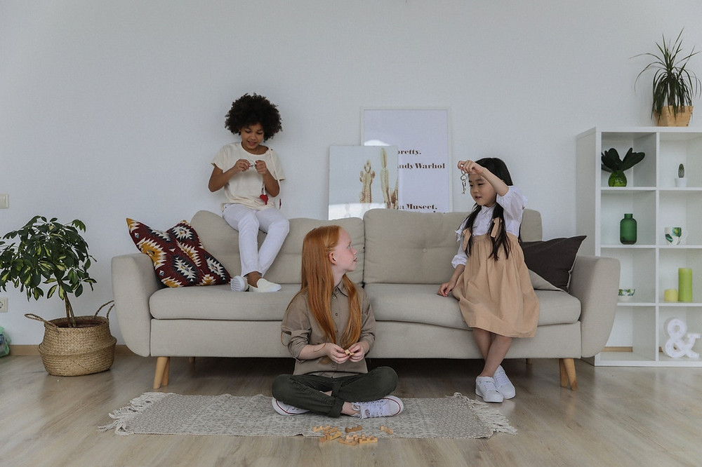 Three girls playing on a sofa