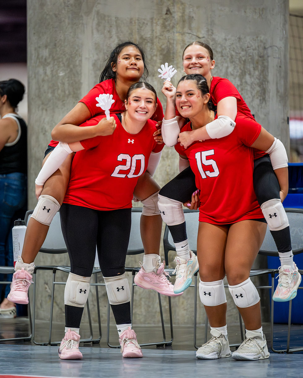 Teammates share a joyful moment, lifting each other up in celebration during a volleyball match, showcasing camaraderie and team spirit.