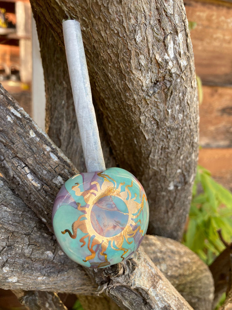 Smooth ceramic smoke stone resting on driftwood