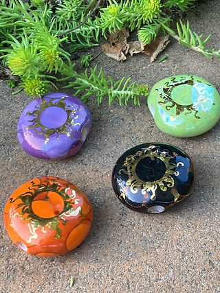 Ancient Creations Ceramics smoke stone hand pipes in Halloween colors, with gold sunshine designs.