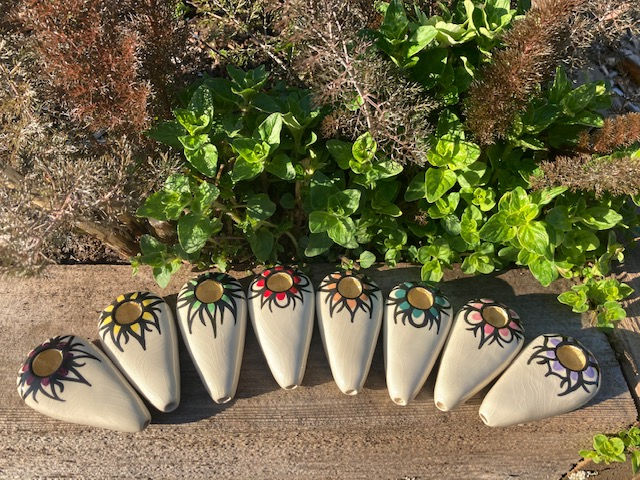 Ancient Creations Ceramics  hand pipes in various colors, with gold sunshine design around the bowl.
