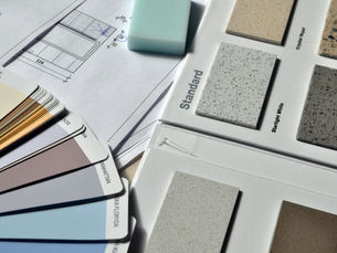 Color palette and material samples for interior renovation projects on a blueprint.