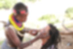 Karo women painting customers face