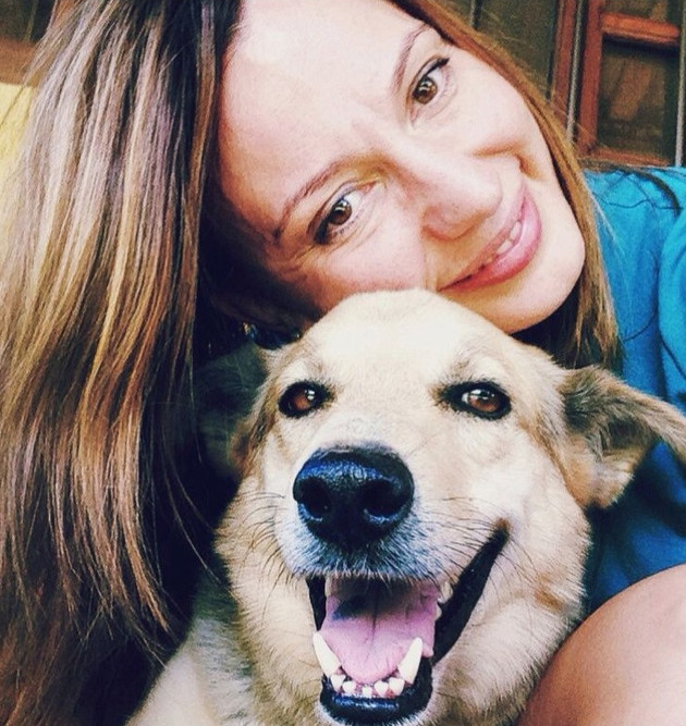 Dog trainer Claudia Lang smiling with a happy dog
